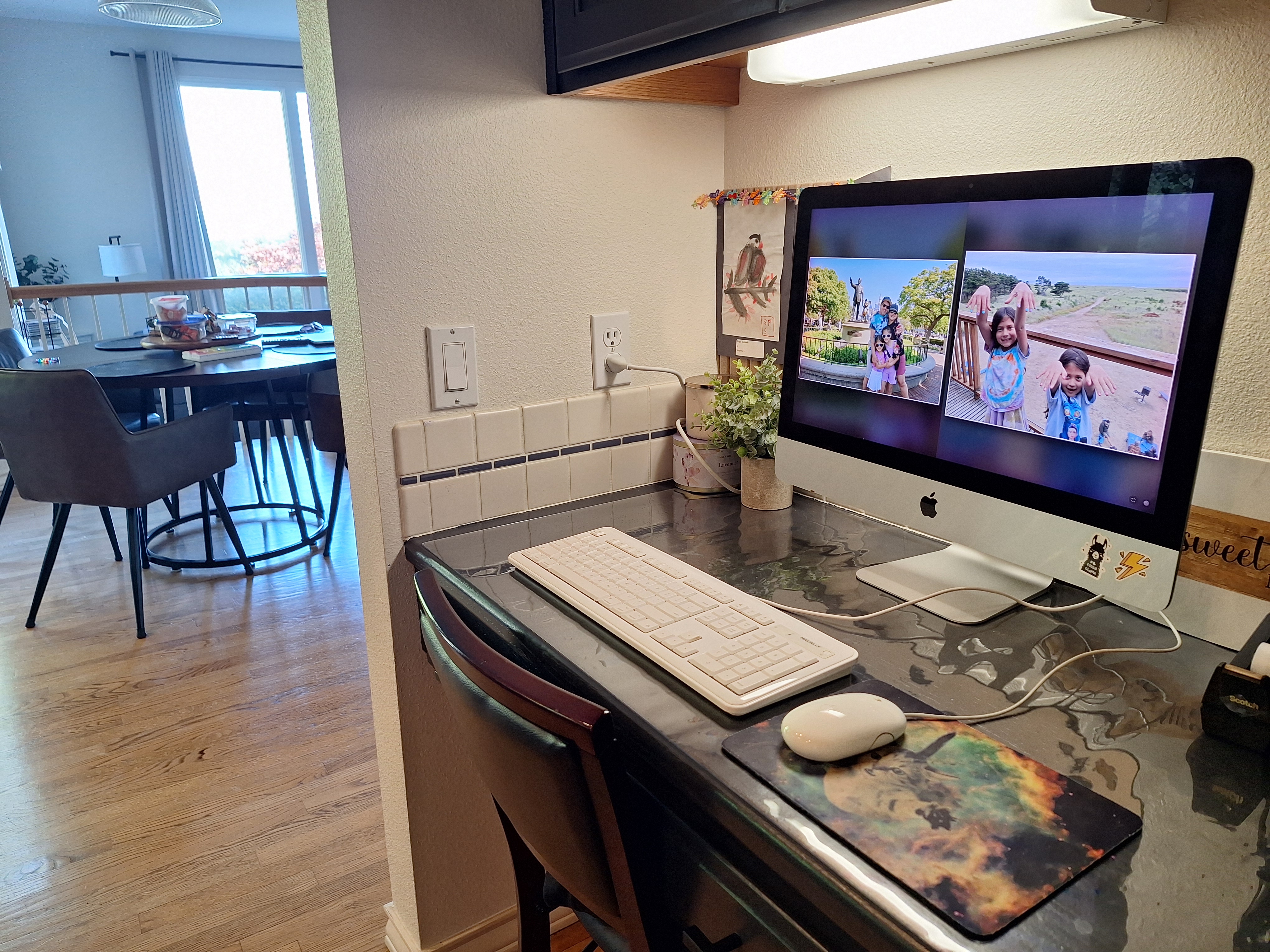 A kitchen iMac displaying two family photos in Dual View.